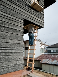 The Coal House outdoor tea room ladder contrasts with the charred siding.